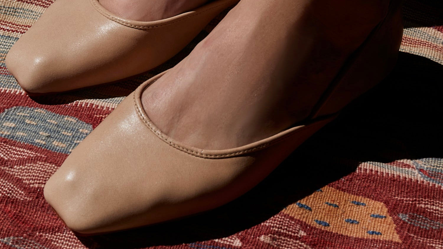 fitted nude leather ballet flats over a colorful rug